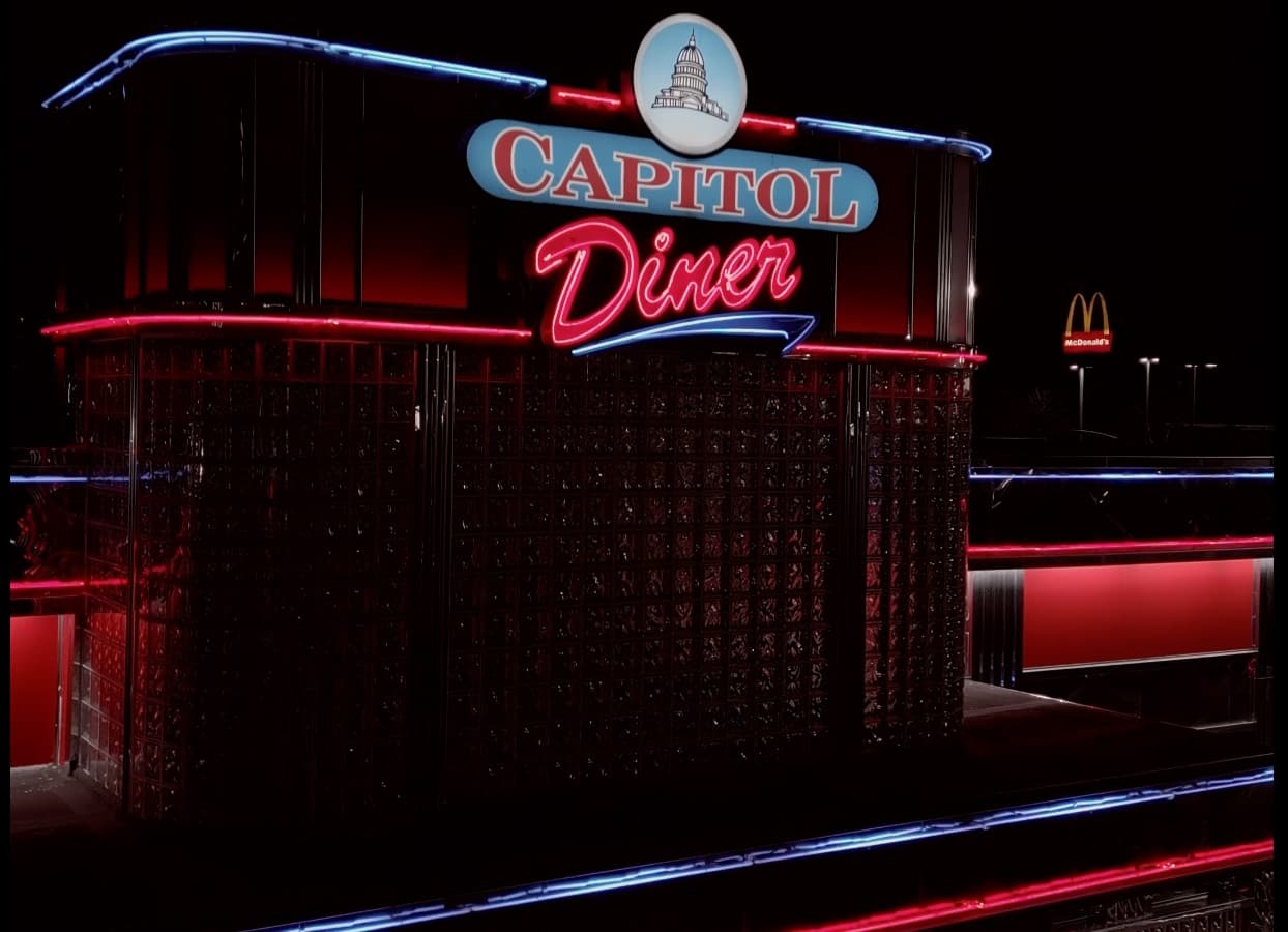 Cinematic reel still: the neon Capitol Diner at night